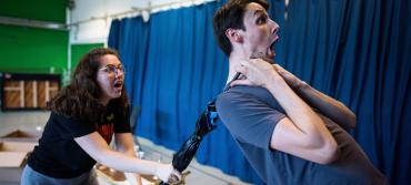 Two students in comedy rehearsal with umbrella prop