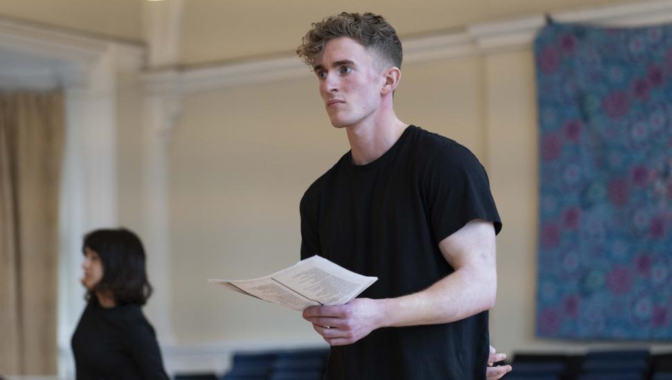 A student holding a script in class